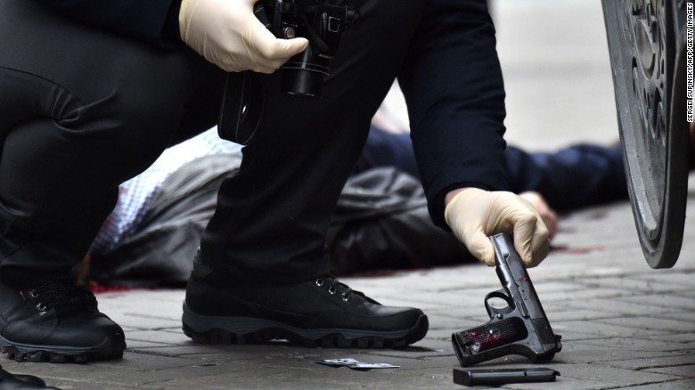 A Ukrainian police officer seizes a gun at the scene where Voronenkov was shot dead on Thursday.