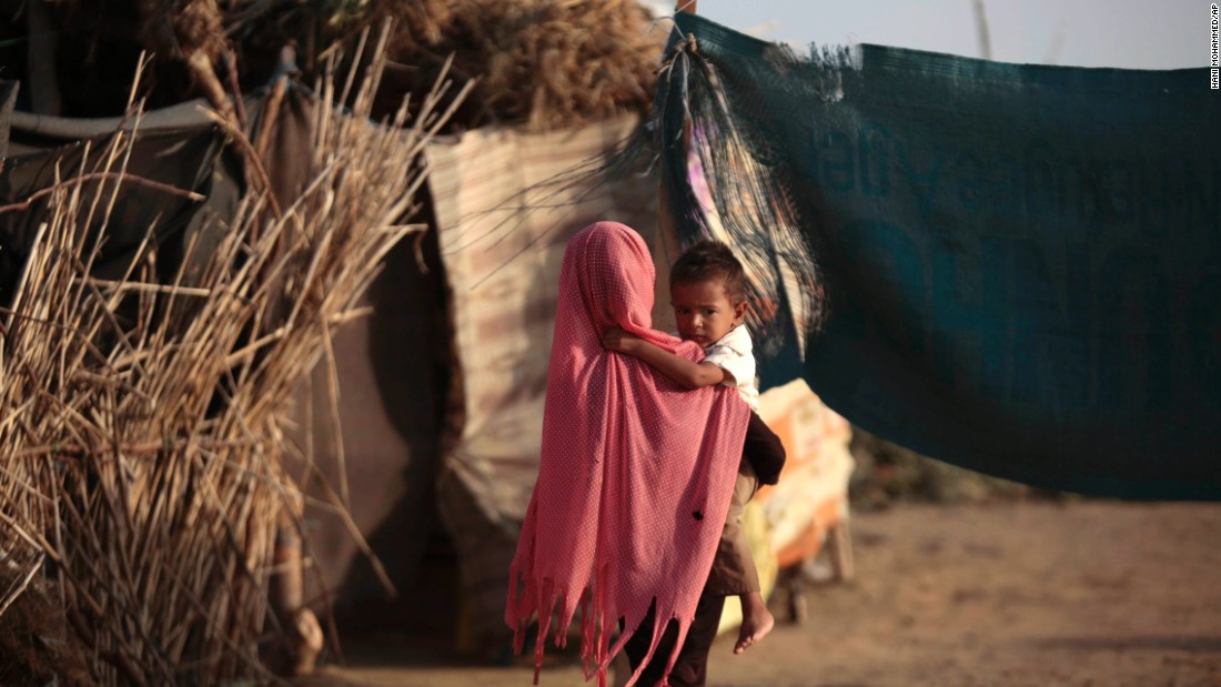 A displaced girl holds her brother at a camp for internally displaced people near the town of Abs, located on Yemen&#39;s western coastal plain.
