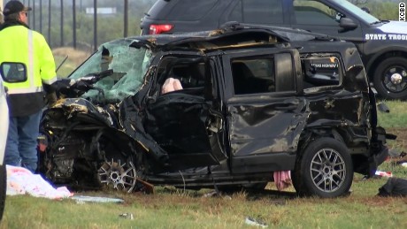 Authorities inspect one of two vehicles involved in a crash that killed three storm chasers in Texas.