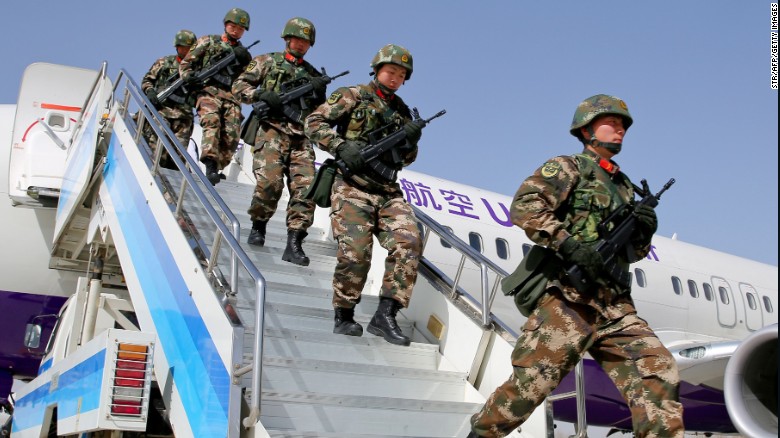 Chinese military police get off a plane to attend an anti-terrorist oath-taking rally in Xinjiang, on February 27.