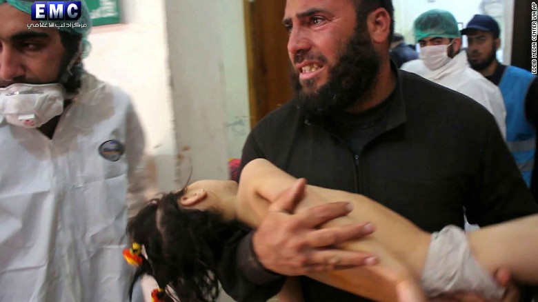 A man carries a child into a makeshift hospital after the attack. 