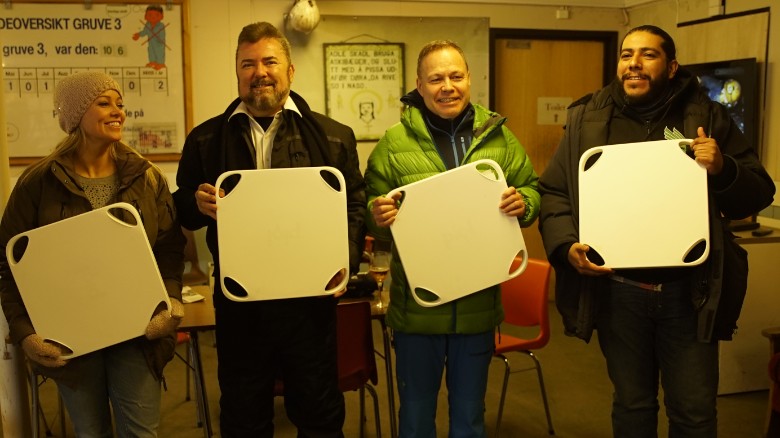Archivists, Piql executives and others display containers that hold coded data on reels of film.