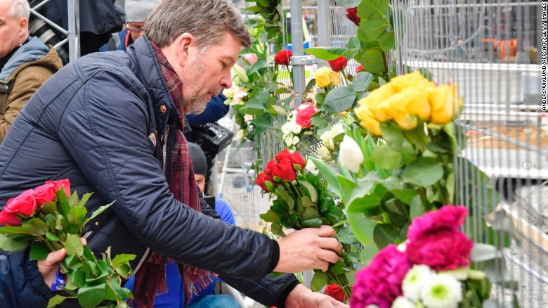 People lay flowers Saturday at the scene of a truck attack in central Stockholm.