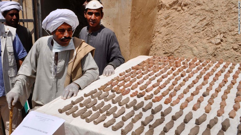 Members of the Egyptian archaeological mission eye funerary figurines known as ushabtis.