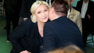 French presidential candidate Marine Le Pen kisses an electoral official after voting in Henin-Beaumont, northwestern France.