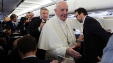 The Pope greets journalists on the airplane en route to Egypt.