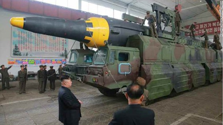 An image from North Korean state media shows leader Kim Jong with a missile on a mobile launcher.