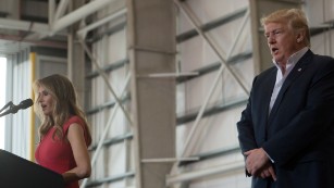 US President Donald Trump listens as his wife, First Lady Melania Trump recites the Lord&#39;s Prayer during a rally in Melbourne, Florida on February 18, 2017. 