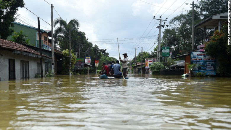 Sri Lankan residents travel by boat through floodwaters in the suburb of Kaduwela in the capital Colombo on May 28, 2017.