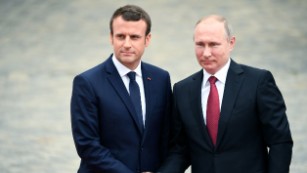 Macron slams Russian news as Putin watches