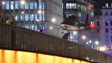 A helicopter flies near London Bridge.