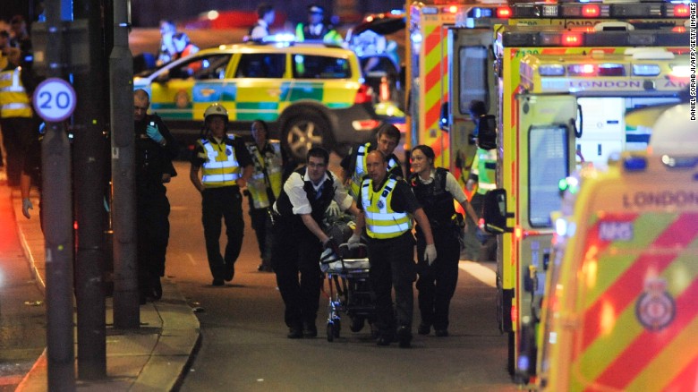Oficiales de policía y miembros de los servicios de emergencia atender a una persona herida en un aparente ataque terrorista en el puente de Londres.