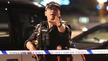 An armed Police officer gestures after the attack in central London.