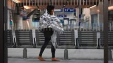 A woman wearing an emergency blanket talks on her phone at London Bridge train station. London Bridge Tube station was closed and London Bridge was closed in both directions.