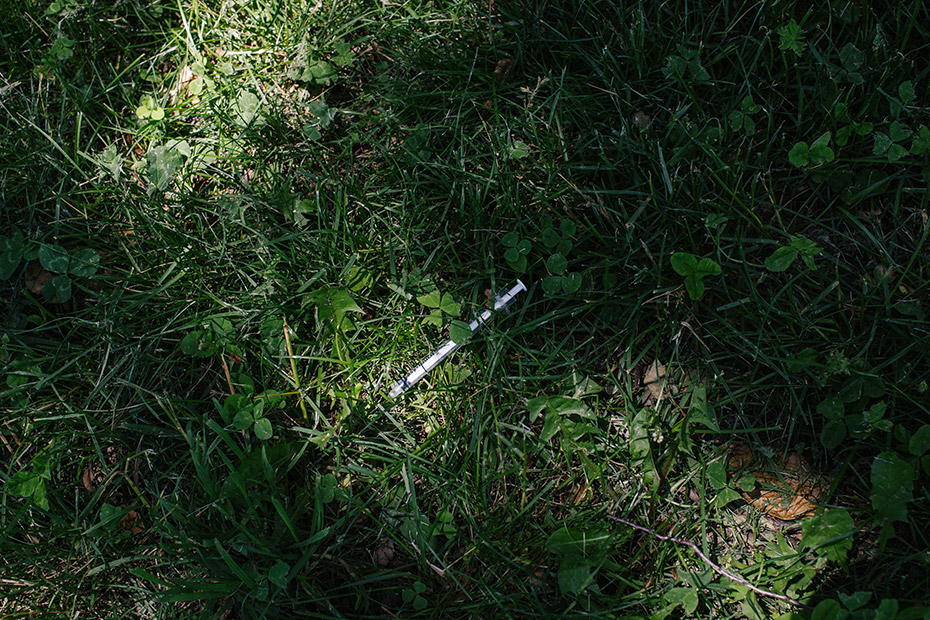 A discarded heroin needle lays in McPherson Square Park, next to the library.