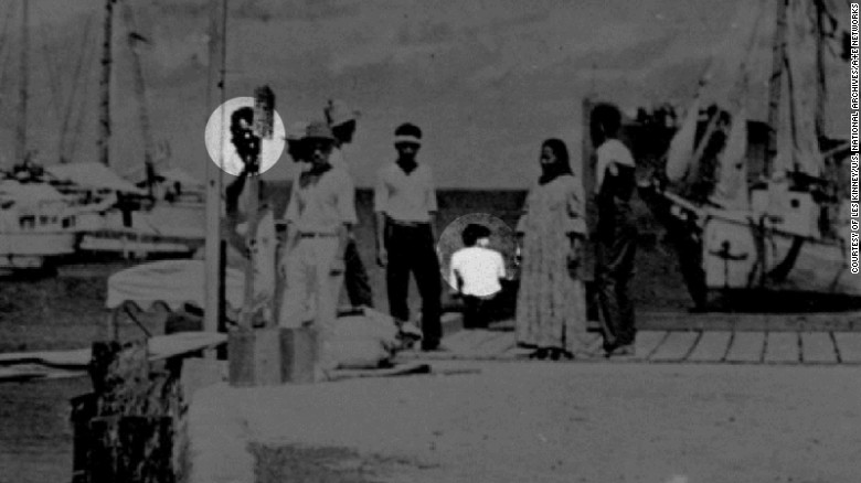 Some experts believe the figure highlighted at left is Fred Noonan and the person sitting, facing away from the camera, is Amelia Earhart.