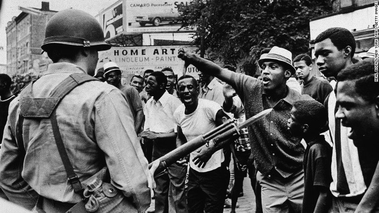 A man gestures with his thumb down to an armed National Guard man, during a protest in Newark, New Jersey, July 14, 1967.