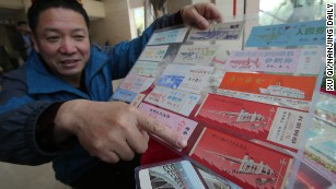 Wang Shiqing is pictured with railway tickets featuring illustrations of the bridge, part of his vast collection.
