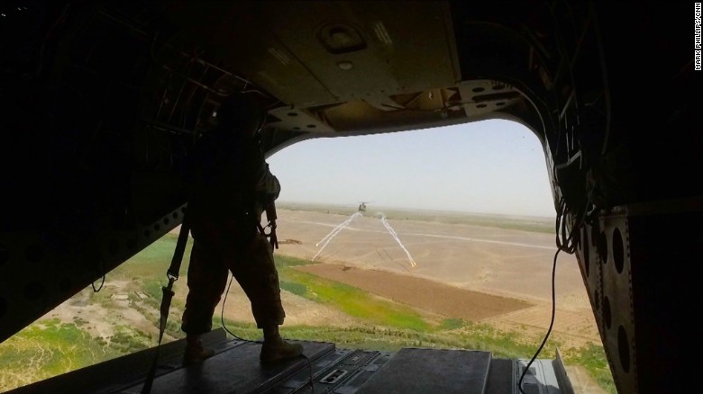 A US Marine stands at the back of a Chinook helicopter en route to Shorsharak.