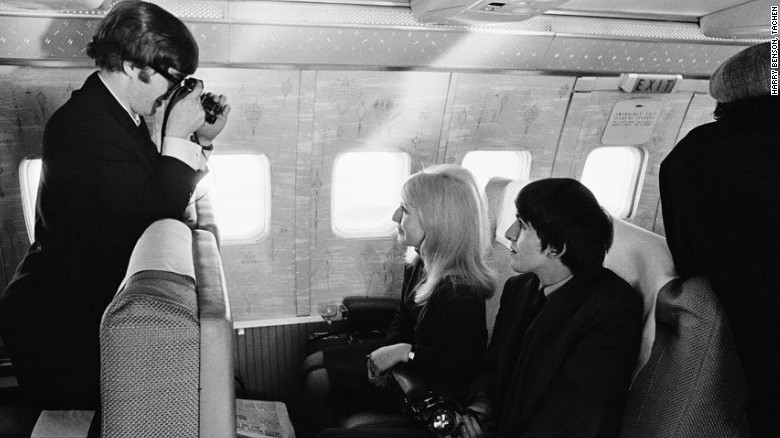 Lennon goes behind the camera to capture Harrison and Lennon&#39;s first wife, Cynthia, on route to New York in 1964. 