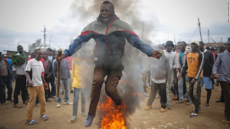 A supporter of the opposition leader Odinga, who leads the National Super Alliance coalition, jumps over a burning tire as he and others protest in Kibera.