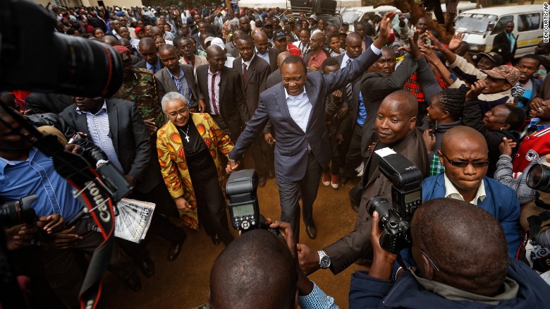 Kenya&#39;s President Uhuru Kenyatta high-fives with supporters after casting his vote in Tuesday&#39;s presidential election. 