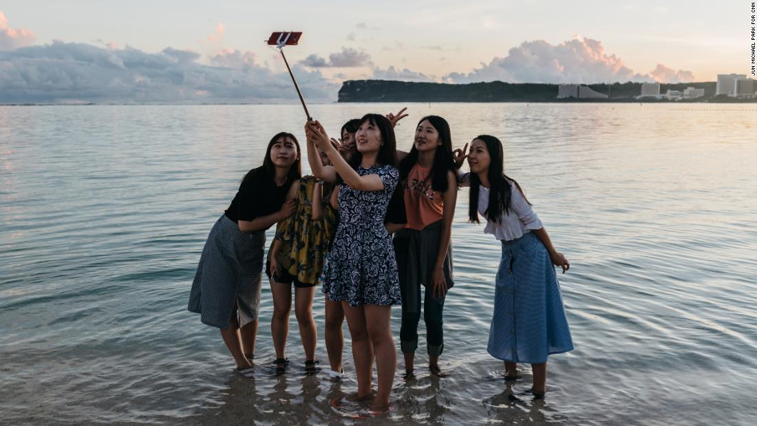 Duhyun Na, right, and her friends take selfies at Ypao Beach Park.