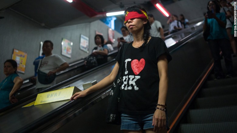 A protester covers her eyes with a China flag to imply Goddess of Justice during the rally supporting Wong, Law and Chow in Hong Kong&#39;s Central district Sunday. 