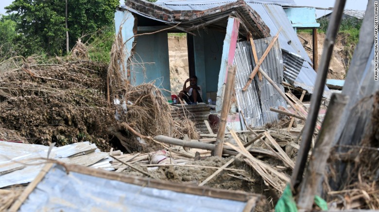 A man rests in his house damaged by flooding some 250 kilometers from Nepal's capital Kathmandu on August 16.