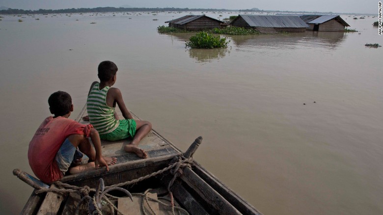 Flood-affected villagers travel by boat in floodwaters in the Morigaon district in the northeastern Indian state of Assam on August 15. 