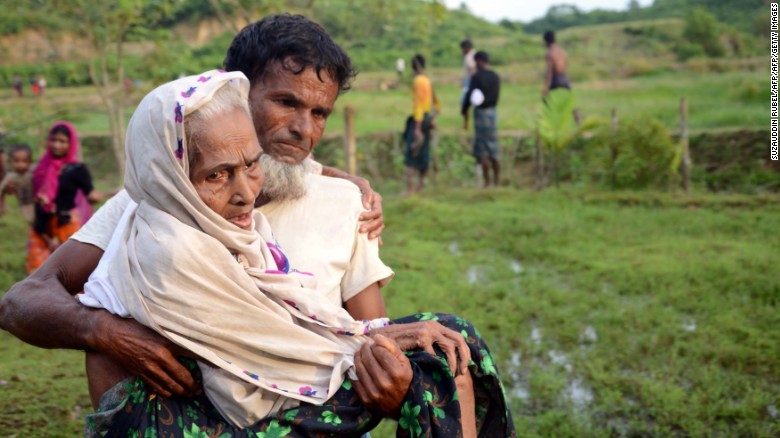 A Rohingya man carries his mother in Ukhiya, Bangladesh, after crossing the border from Myanmar.