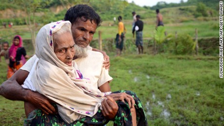 A Rohingya man carries his mother in Ukhiya Bangladesh after crossing the border from Myanmar