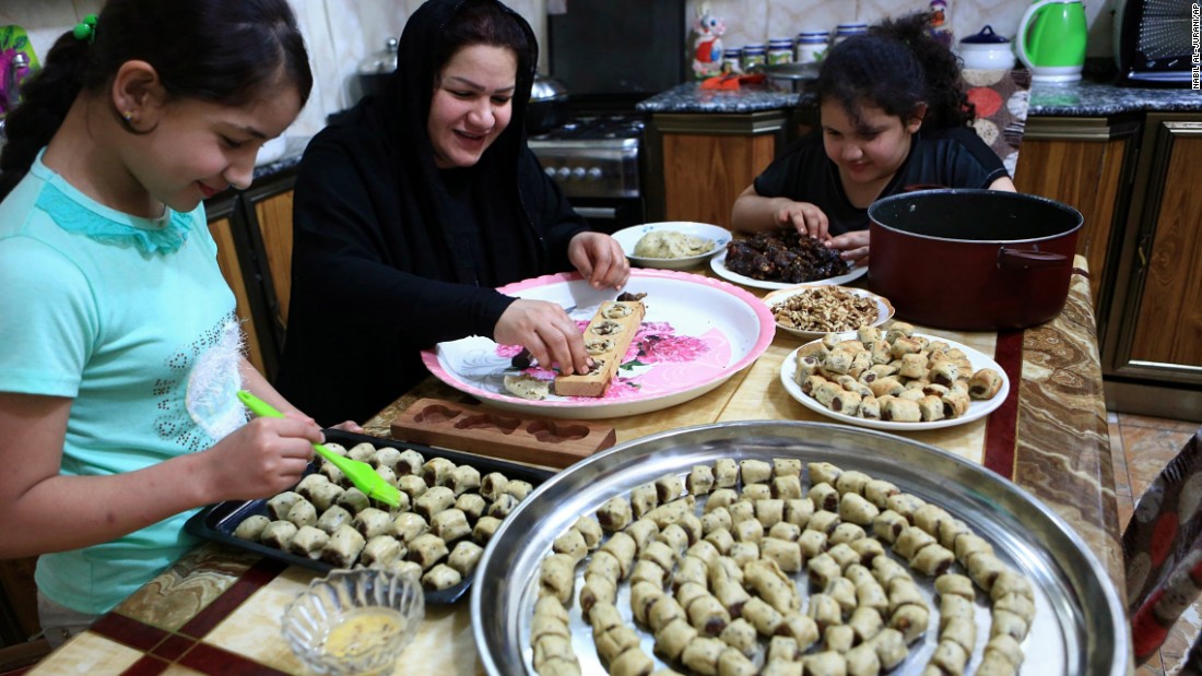 An Iraqi mother and her children prepare cookies for the upcoming Muslim Eid al-Adha holiday in Basra, Iraq on Thursday.