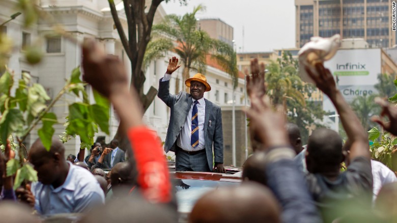 Opposition leader Raila Odinga smiles and waves to a crowd of his supporters as he leaves the Supreme Court on Friday