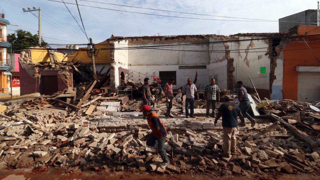 People stand on a building&#39;s rubble in Juchitan on September 8.