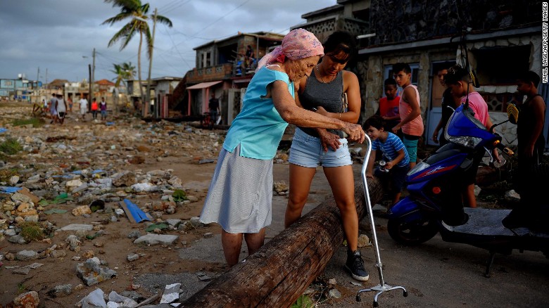 People make their way through debris in the Cojimar neighborhood of Havana.