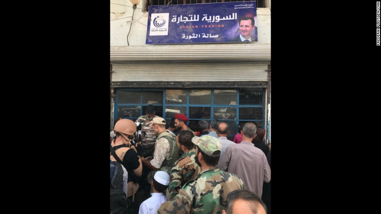 People line up outside a small store in central Deir Ezzor.