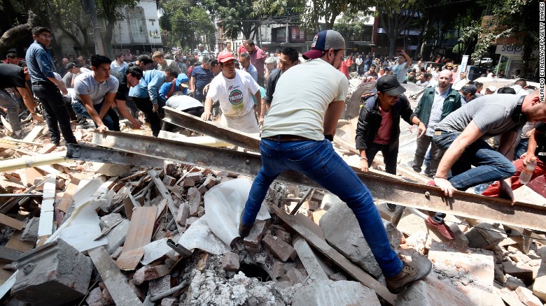 People remove debris off a building that collapsed after an earthquake rattled Mexico City.