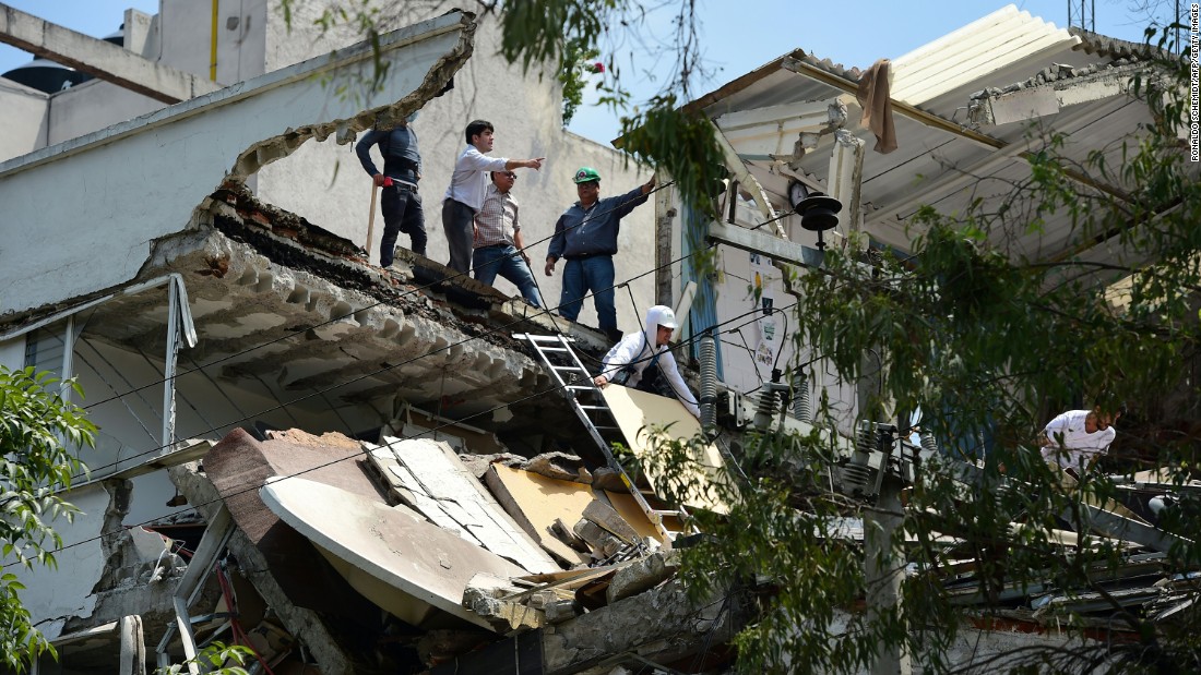 People stand inside a Mexico City building that collapsed in the quake.