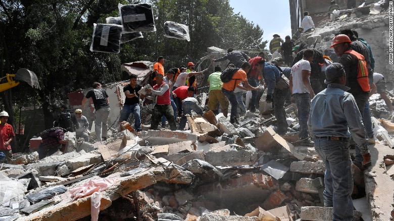 People remove debris from a collapsed building in Mexico City after a magnitude-7.1 earthquake hit the region on Tuesday, September 19.