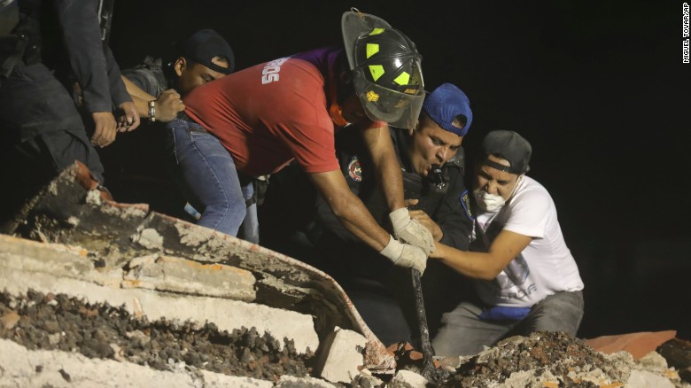 Rescue workers and volunteers search a building that collapsed  in Mexico City after a magnitude-7.1 earthquake hit the region on Tuesday, September 19.