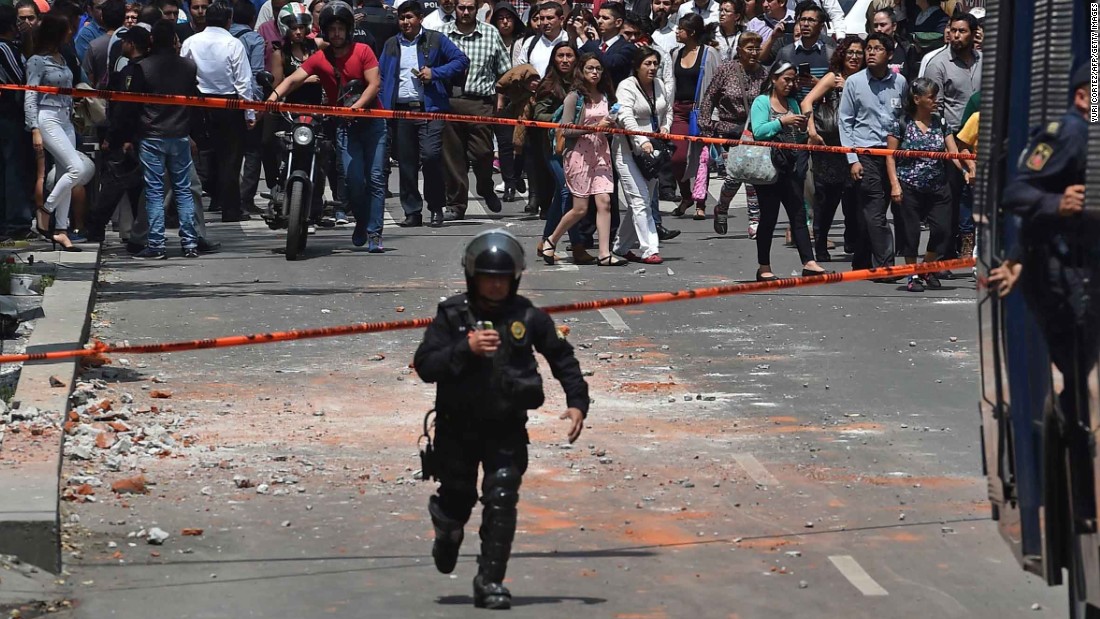 A police officer runs toward the site where a building collapsed in Mexico City on September 19.