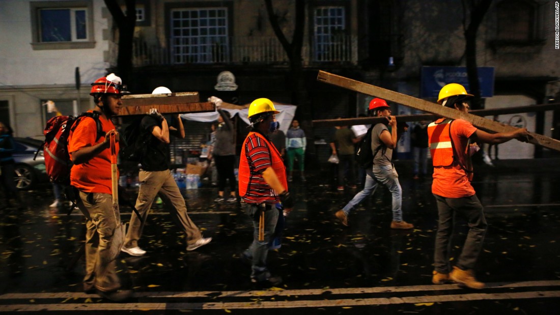 A group of men calling themselves the Insurgentes Brigade arrive carrying beams of wood to offer their services at a site of earthquake damage in the Roma neighborhood in Mexico City, September 20.