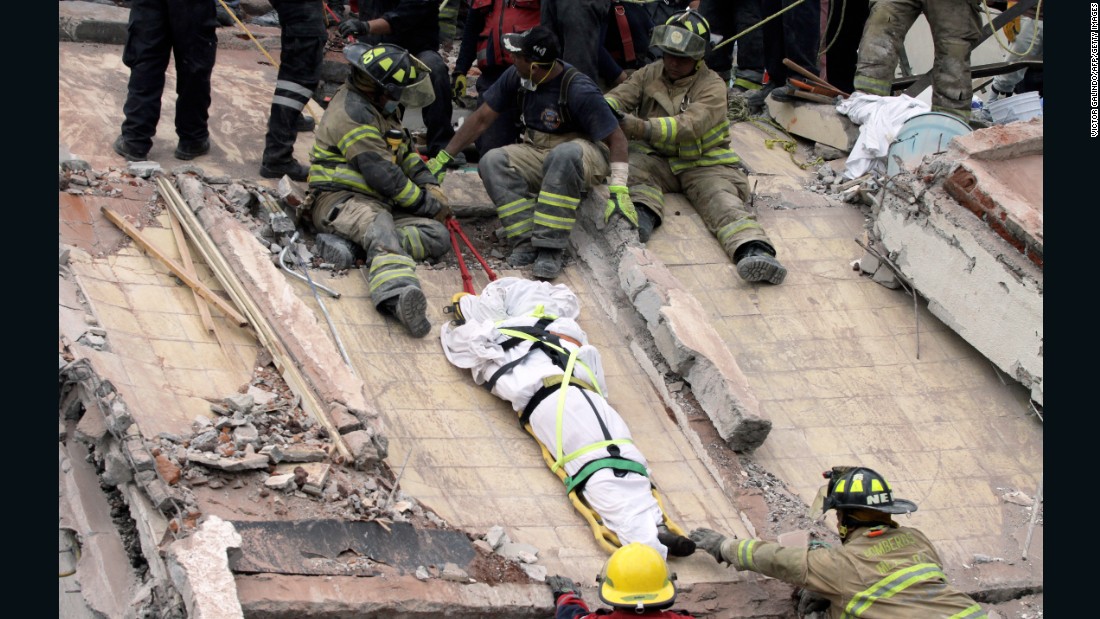 Rescuers and firefighters lower a corpse on September 20, from a house that was destroyed by the earthquake in Mexico City.
