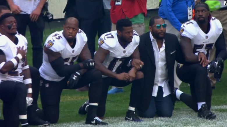 Retired Ravens linebacker Ray Lewis, in a sportcoat, joined his former team during Sunday&#39;s protest. 