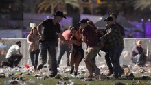 Concertgoers help an injured person at the scene.