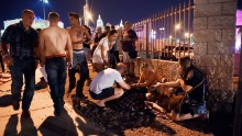 People gather around a victim outside the festival grounds.