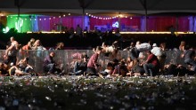 Concertgoers dive over a fence to take cover from gunfire on Sunday night.