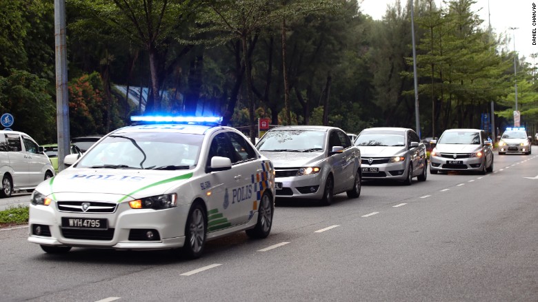 Police cars carrying the two suspects enter the Shah Alam court house outside Kuala Lumpur, Malaysia on Monday, Oct. 2.