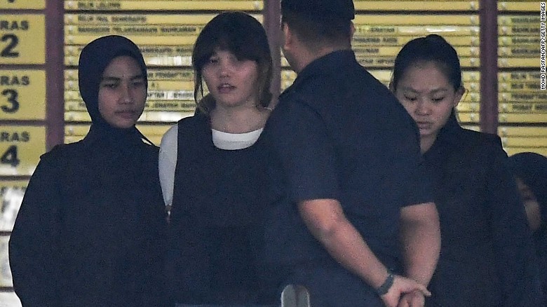 Police escort Vietnamese defendant Doan Thi Huong (2nd left) after her trial on October 2.